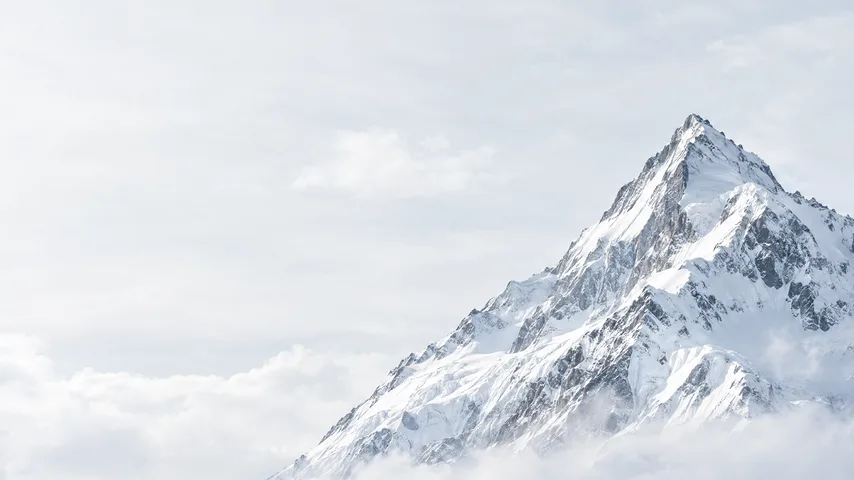 A snow-covered peak rising above the clouds.